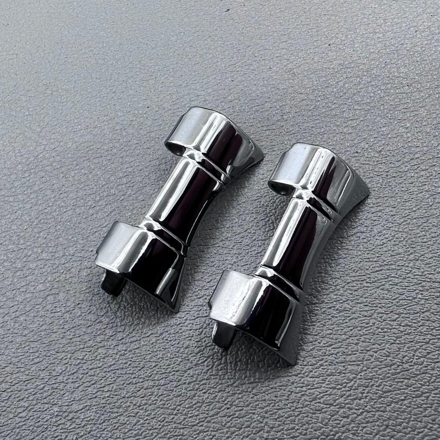 Set of 2 silver steel curved end links with spring bars for 24x12mm watch bands, enhancing bracelet fit.