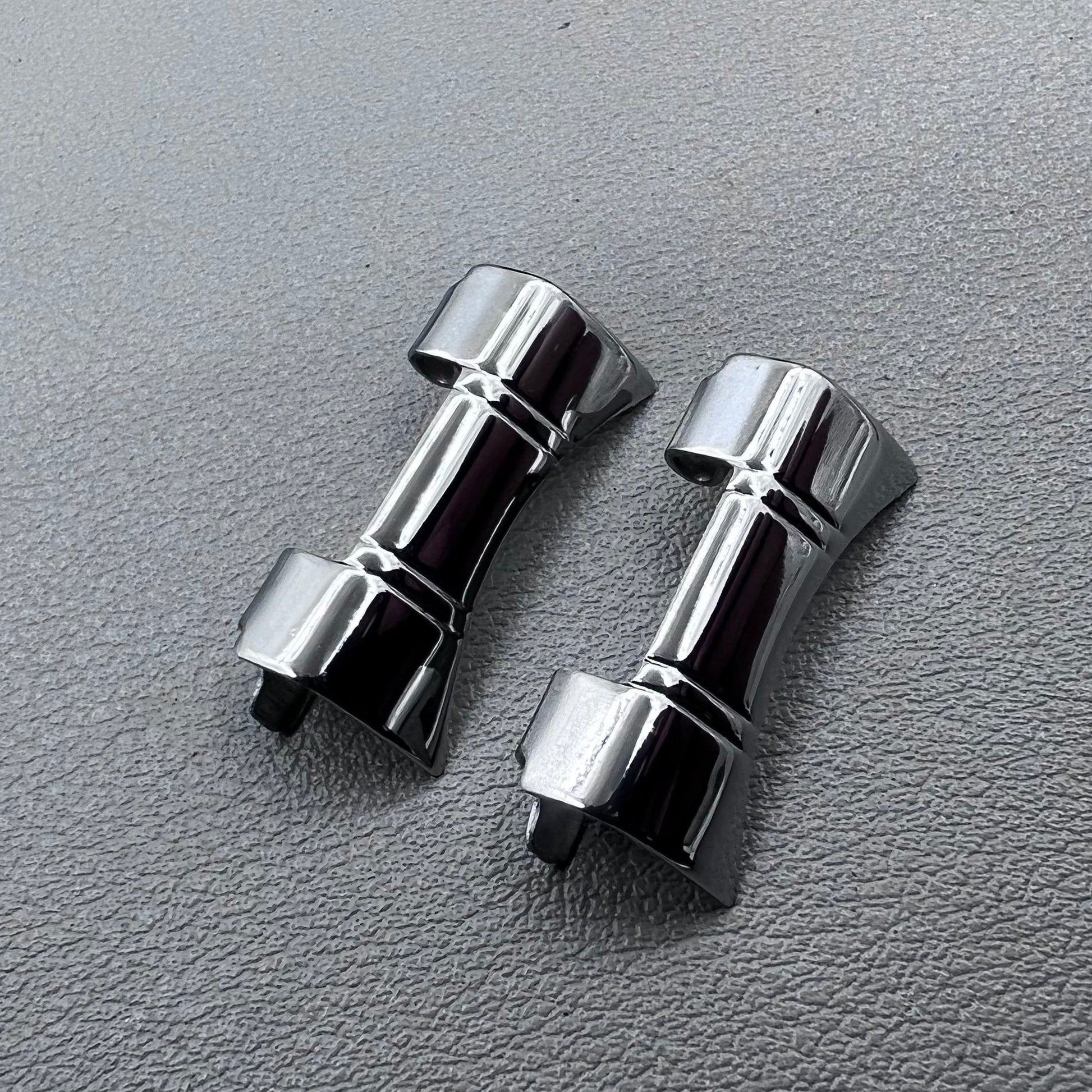 Set of 2 silver steel curved end links with spring bars for 24x12mm watch bands, enhancing bracelet fit.