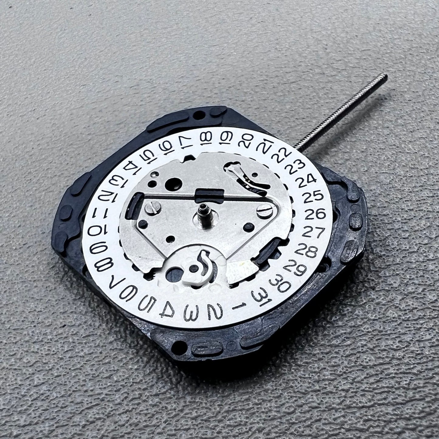 Japan VX22 quartz watch movement with date at 3 o'clock, white disk replacement for precision.