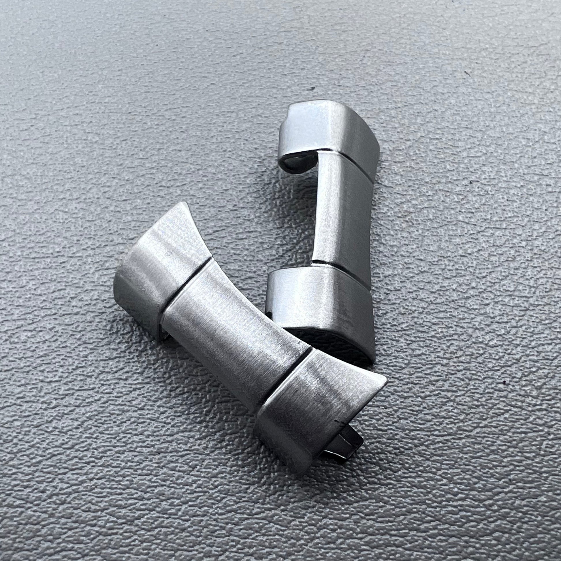 Set of 2 polished silver steel curved end links, 20x10mm, for secure watch band attachment.