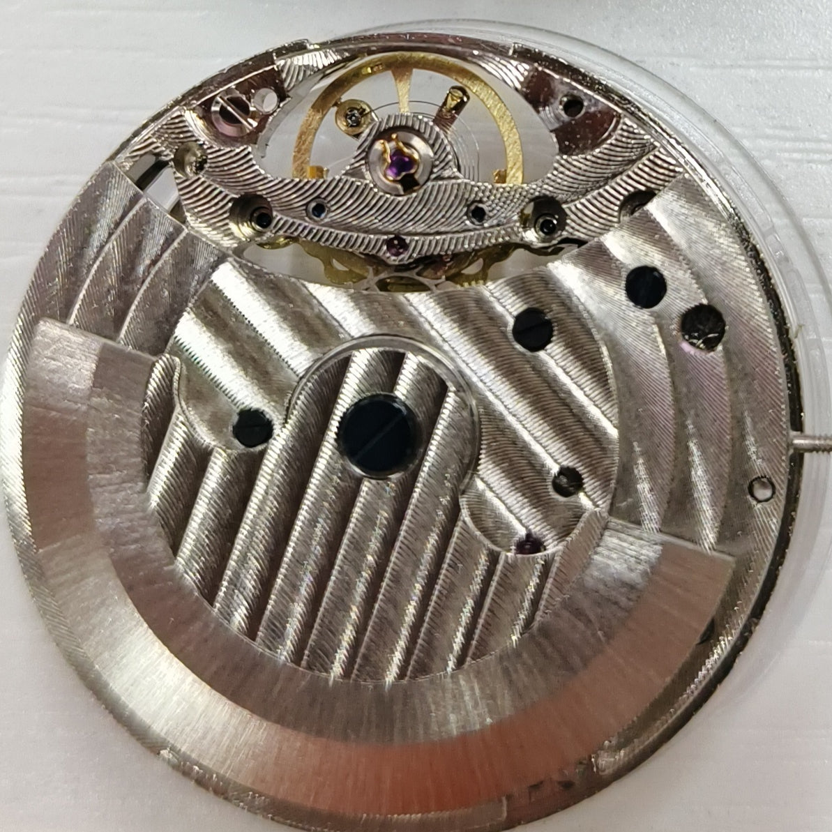 Silver hollow mechanical watch accessory with big flywheel and moonphase at 12, China-made craftsmanship.