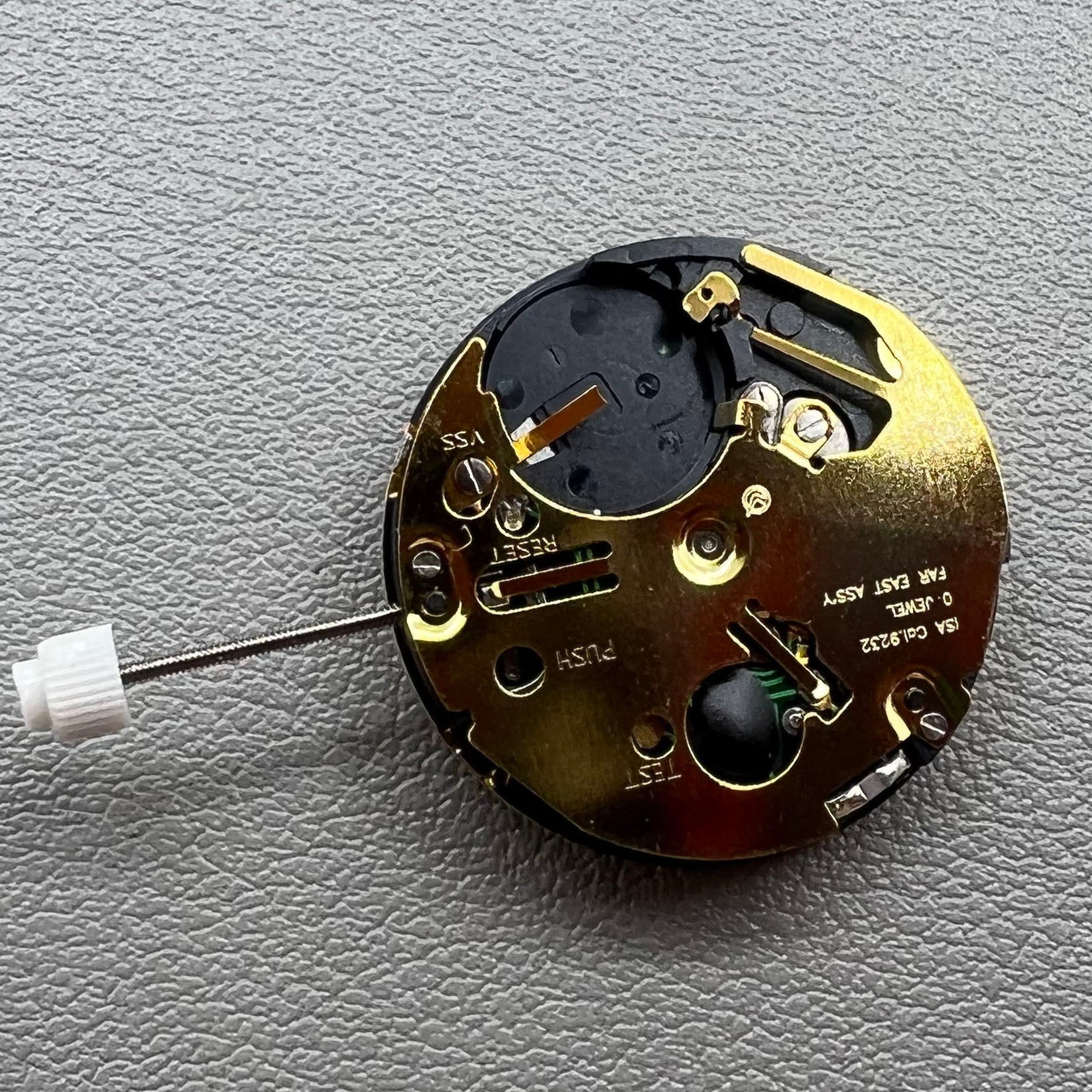Swiss ISA 9232 quartz watch movement with six hands, date at 3, small seconds at 6/9/12, precision timekeeping.