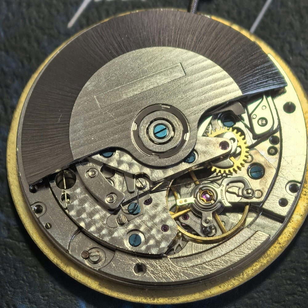 Chinese Dandong 7750 mechanical watch movement displaying date at 3 o'clock and subdials at 6, 9, and 12 positions.