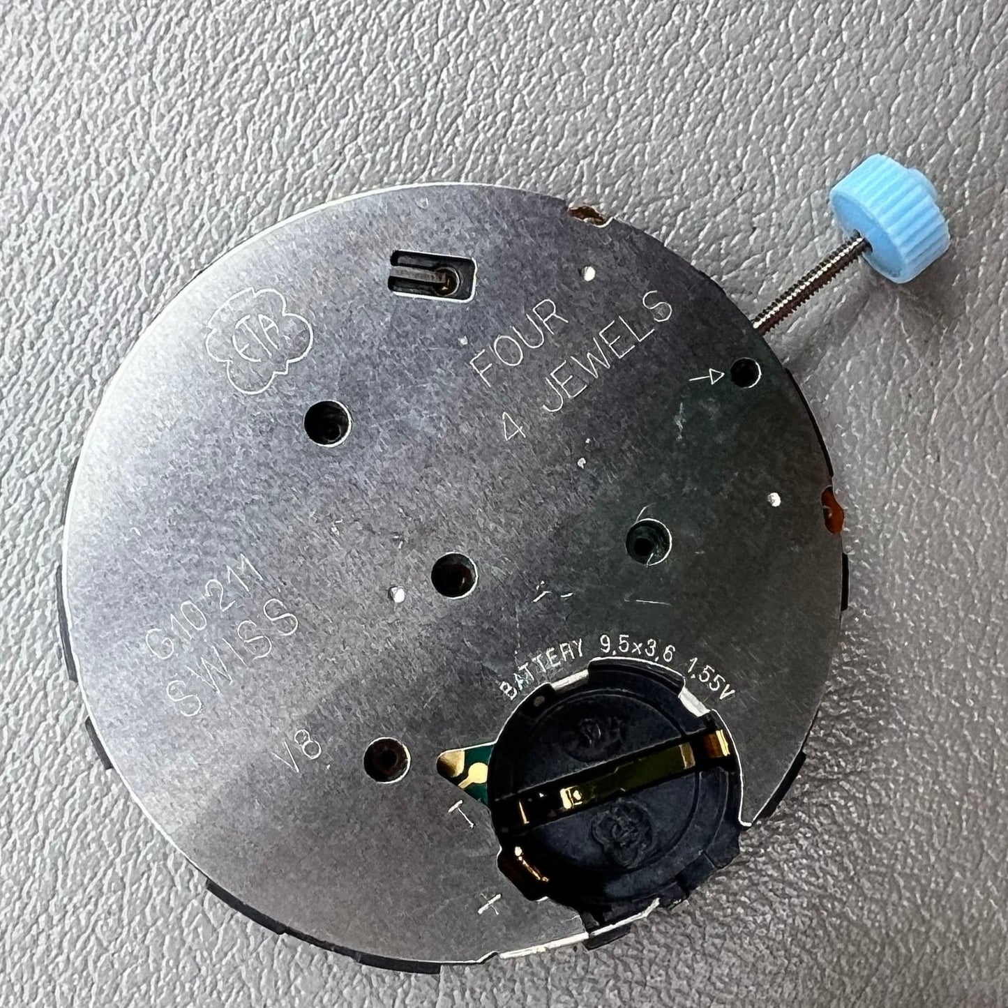 Swiss ETA G10.212 quartz watch movement with date at 4, large hands, small seconds, and black disk by ETA.