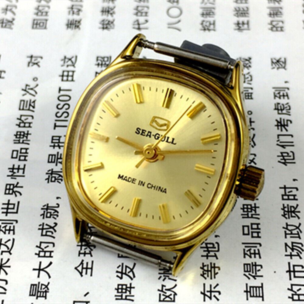 Golden dial ladies watch by Tianjin Seagull with manual mechanical movement and sleek stainless steel strap.