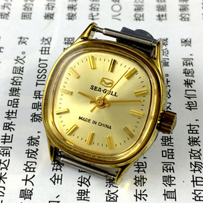 Golden dial ladies watch by Tianjin Seagull with manual mechanical movement and sleek stainless steel strap.