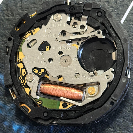 Citizen Eco-Drive E100 quartz watch movement showing day and date at 3 o'clock position.