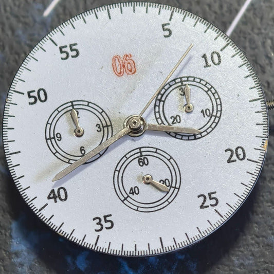 Close-up of Chinese Dandong 7750 mechanical watch movement featuring small second subdials at 3, 6, and 9 o'clock positions.