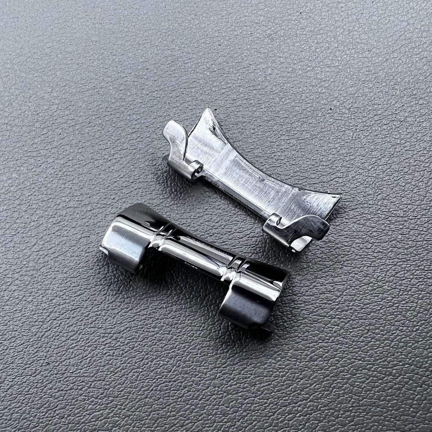 Set of 2 silver steel curved end links with spring bars for 24x12mm watch bands, enhancing bracelet fit.