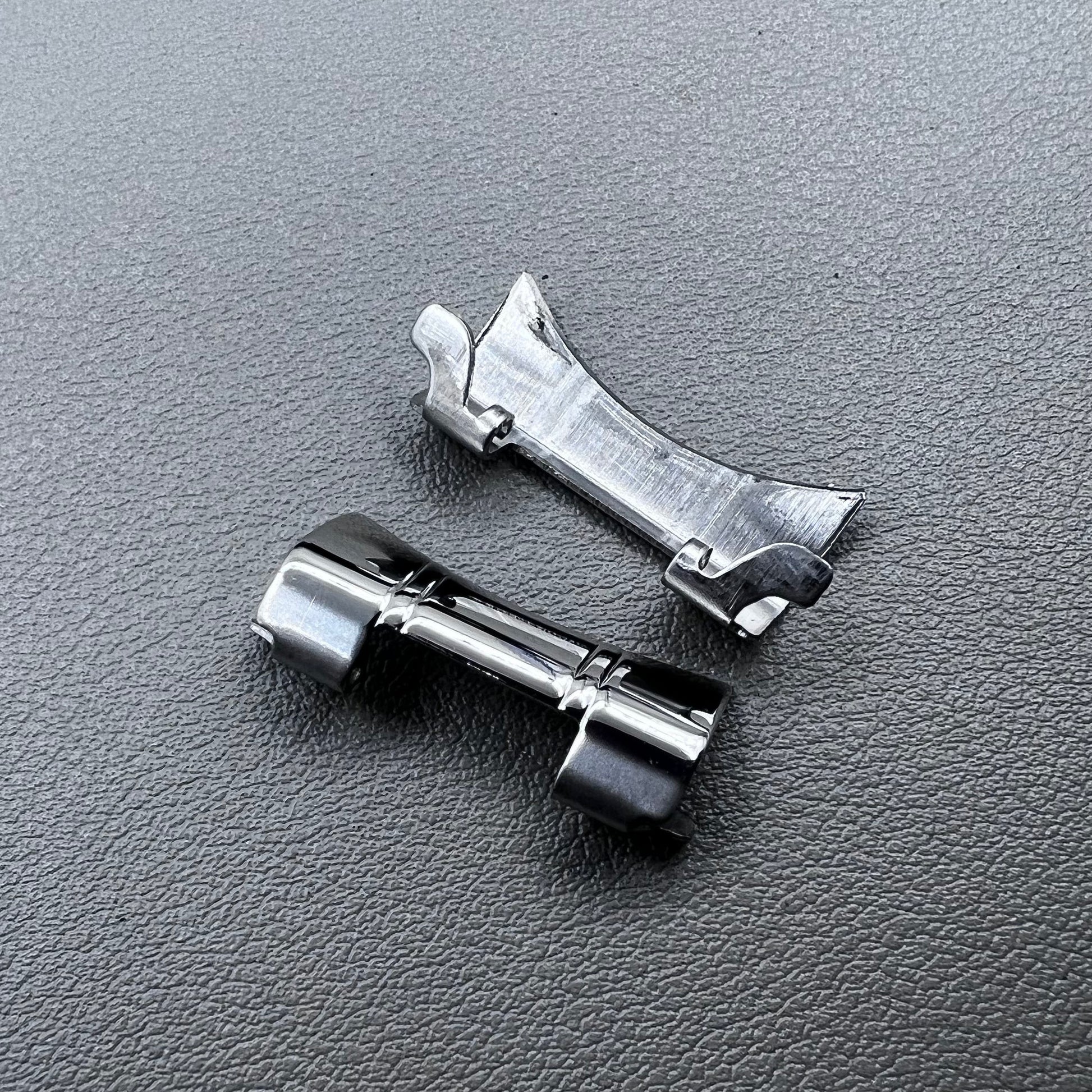 Set of 2 silver steel curved end links with spring bars for 24x12mm watch bands, enhancing bracelet fit.