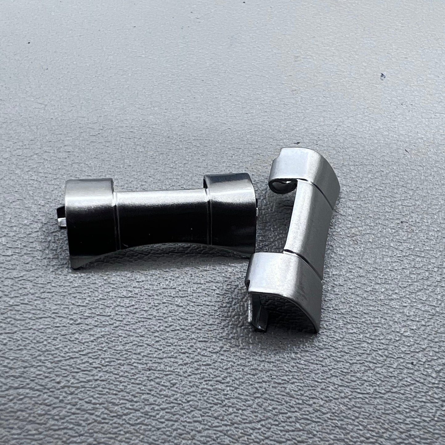 Set of 2 polished silver steel curved end links, 20x10mm, for secure watch band attachment.