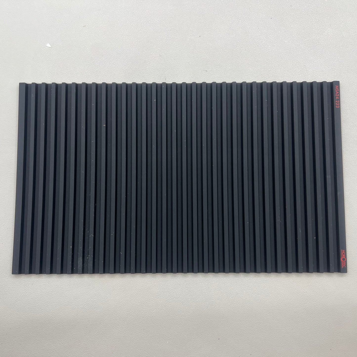 Swiss Horotec black silicon anti-slip bench mat with 32 grooves, ideal for watch repair tools organization.
