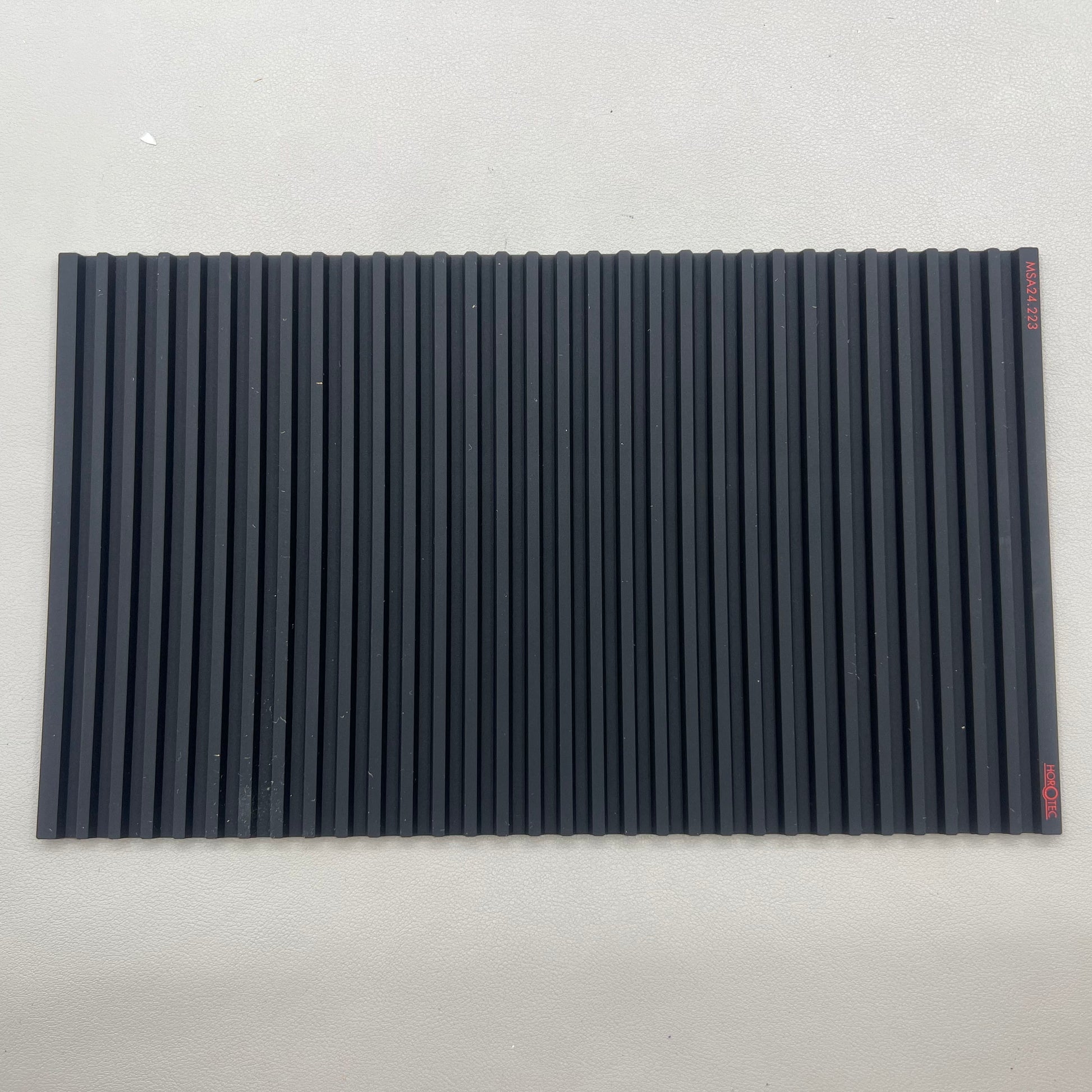 Swiss Horotec black silicon anti-slip bench mat with 32 grooves, ideal for watch repair tools organization.