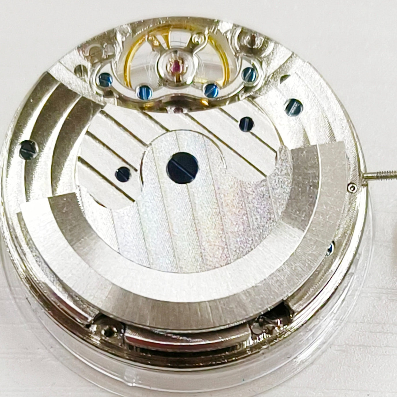 Silver hollow mechanical watch repair part with large flywheel, precise movement for China-made timepieces.