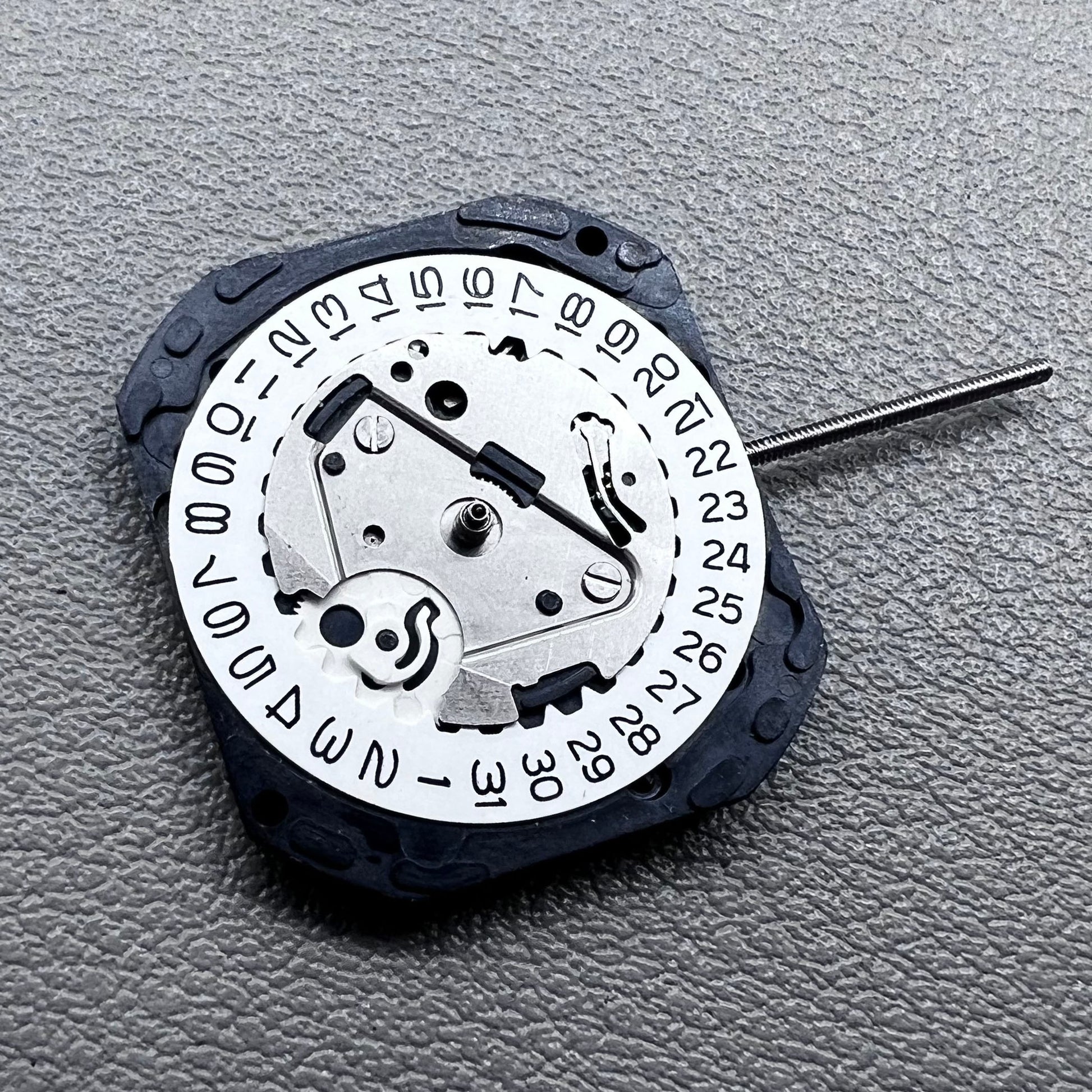 Japan VX22 quartz watch movement with date at 3 o'clock, white disk replacement for precision.
