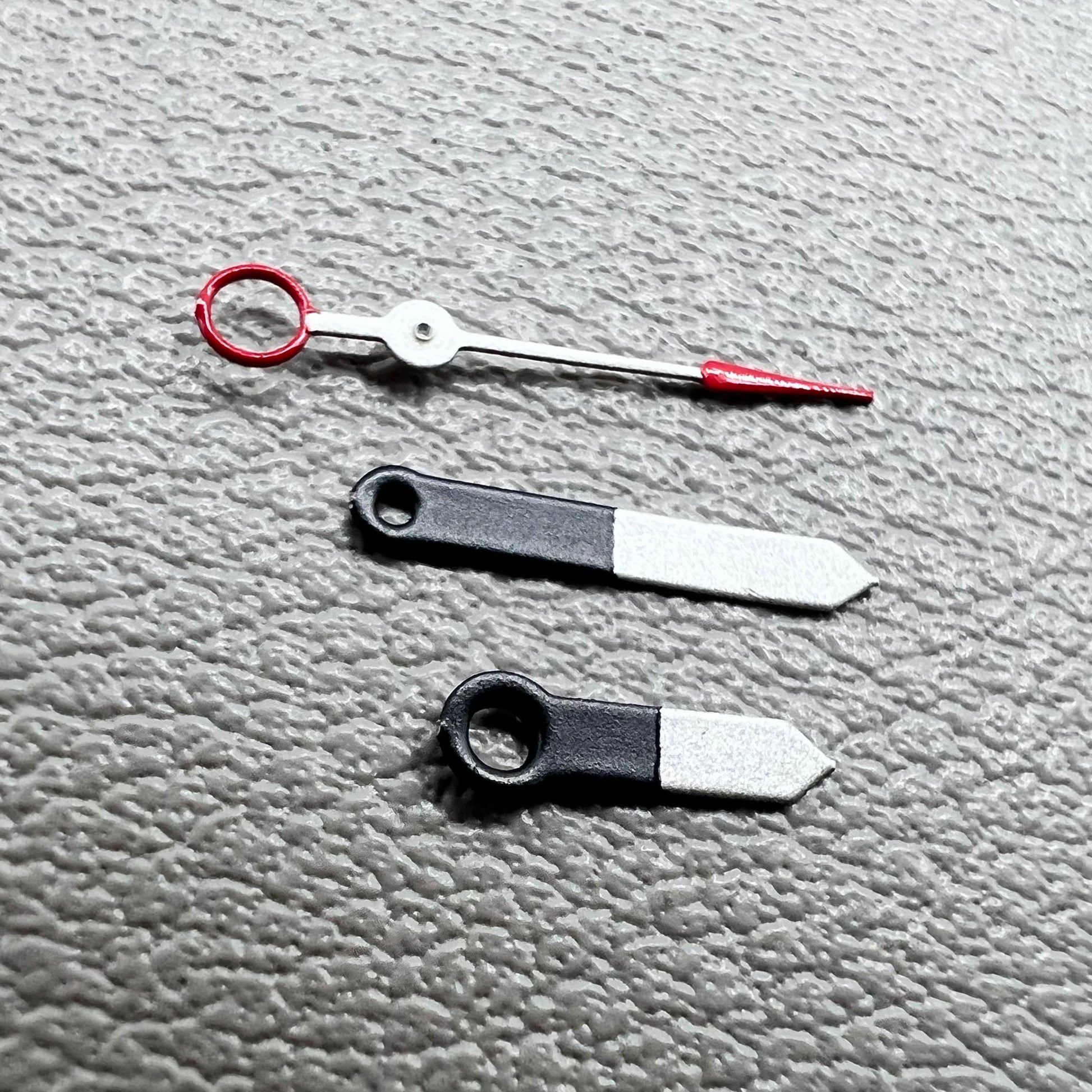 Set of black and white painted trim arrow-shaped watch hands without lume for Ronda 515, ideal for precise timekeeping.