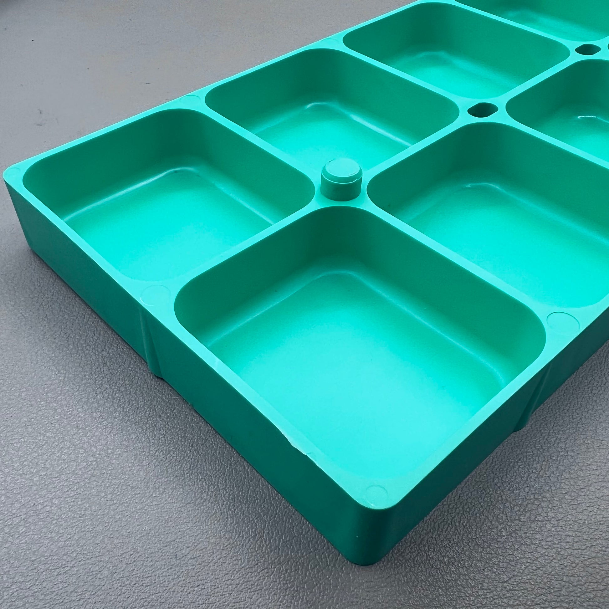 Swiss Horotec green plastic container with 10 compartments for organizing watch accessories.