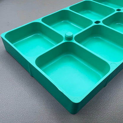 Swiss Horotec green plastic container with 10 compartments for organizing watch accessories.