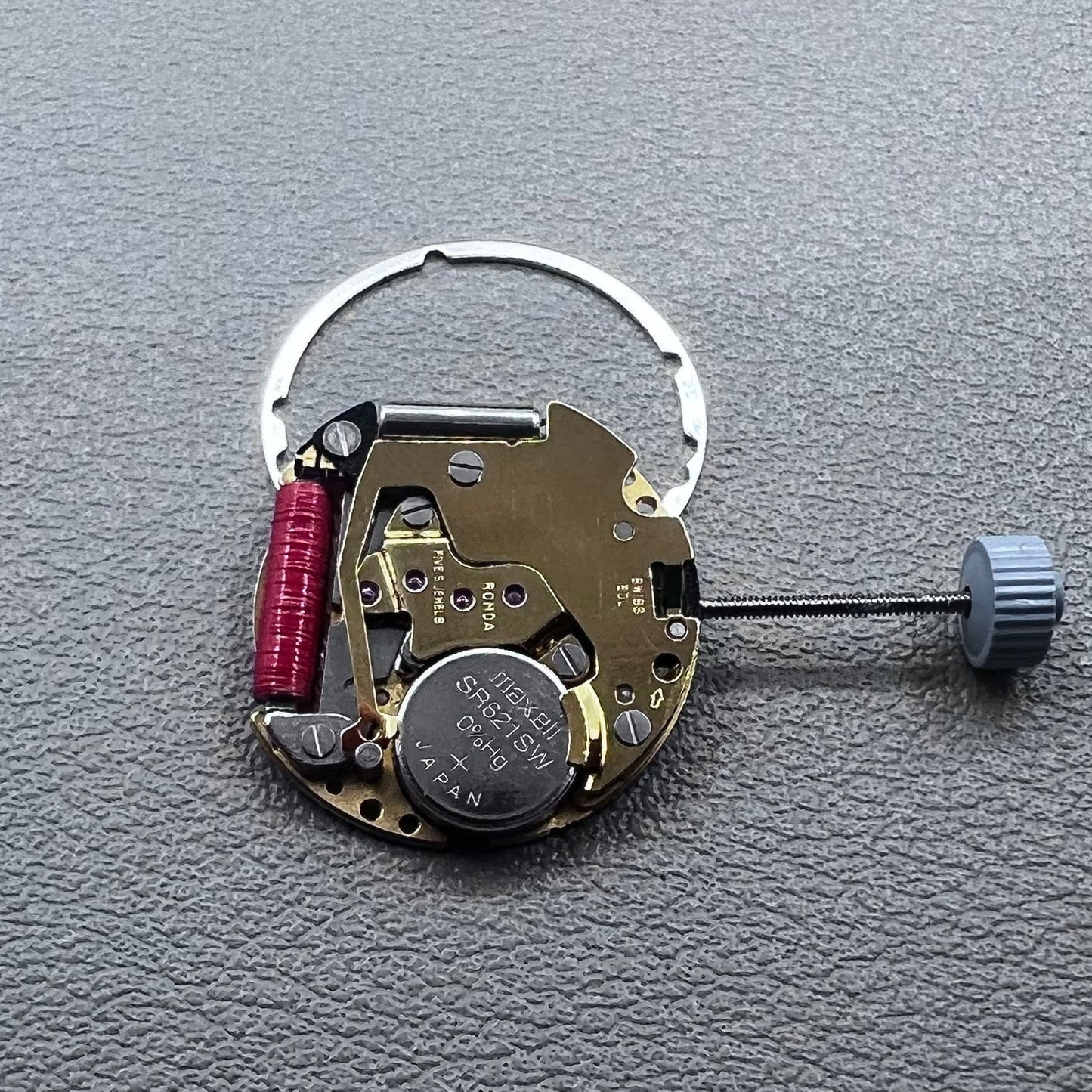 Swiss Ronda 775 quartz watch movement with golden finish, date at 6, and three hands.