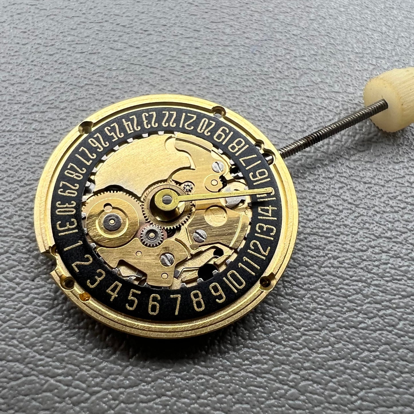 Swiss ETA 256.041 quartz watch movement with black disk, 2 hands, and date at 6, precise timekeeping.