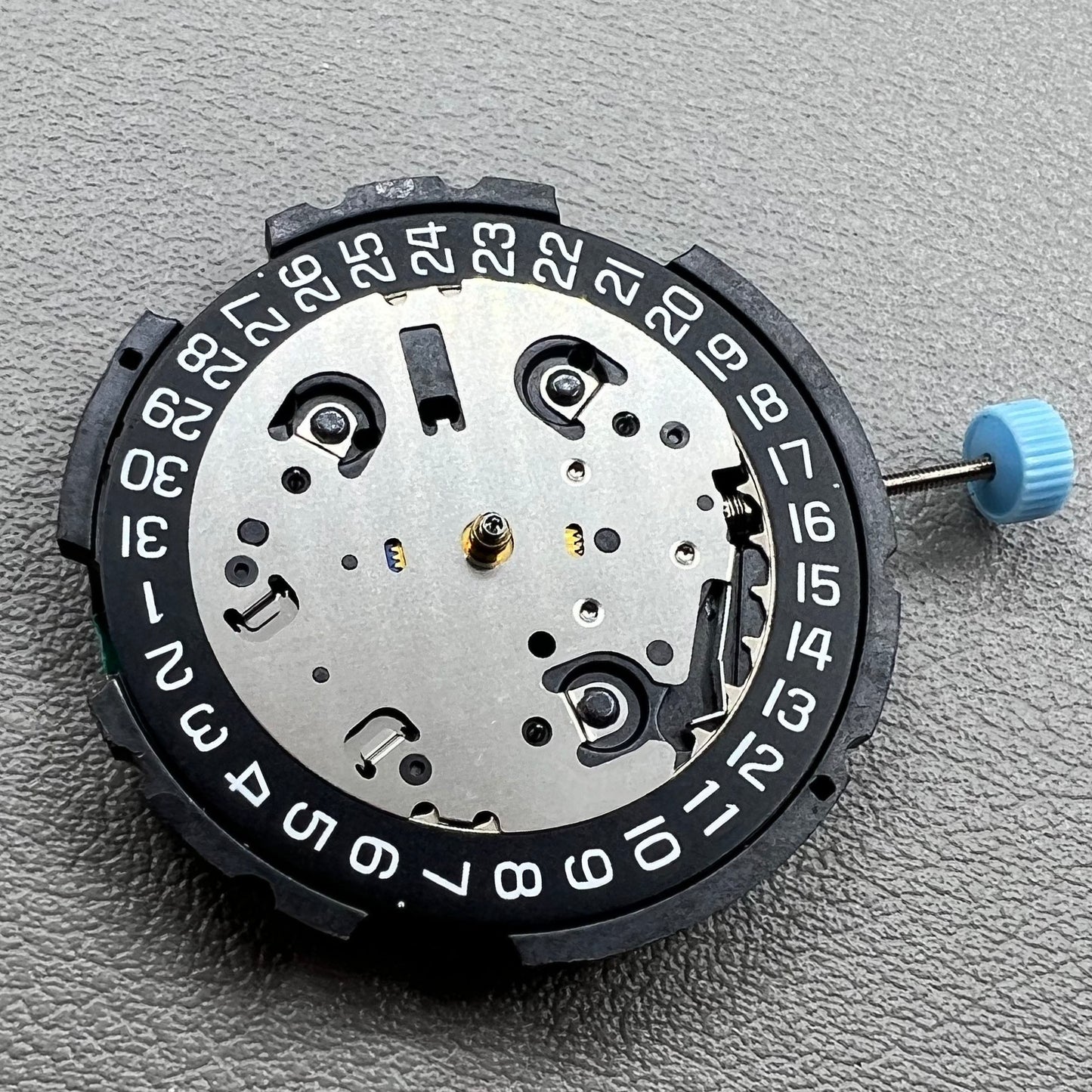 Swiss ETA G10.212 quartz watch movement with date at 4, large hands, small seconds, and black disk by ETA.