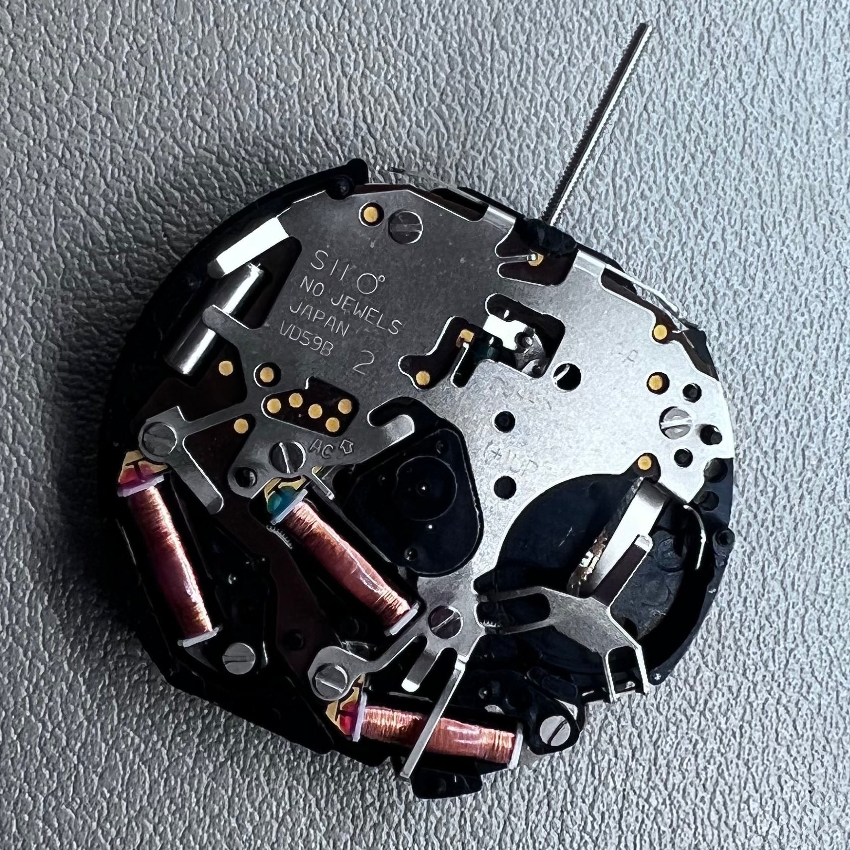 Original Japan VD59 watch movement close-up showing multifunctional quartz small second at 6/9/12 o'clock positions.