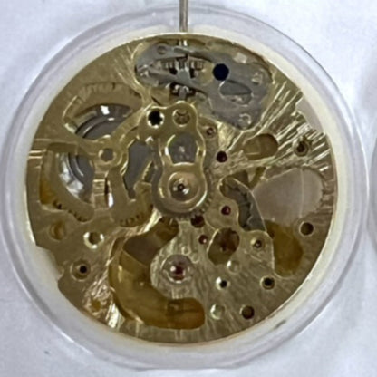Dandong 7120 golden mechanical watch movement showcasing 3 hands and hollow design with automatic fork mechanism.