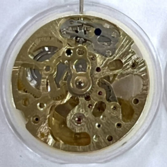 Dandong 7120 golden mechanical watch movement showcasing 3 hands and hollow design with automatic fork mechanism.