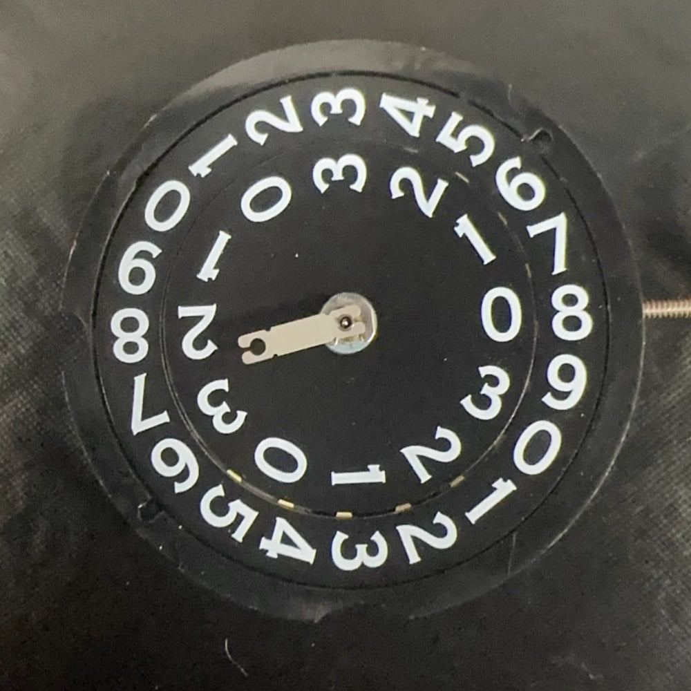 Swiss Made RODNA 509 black disk watch part with quartz movement and date display at 3 o'clock.