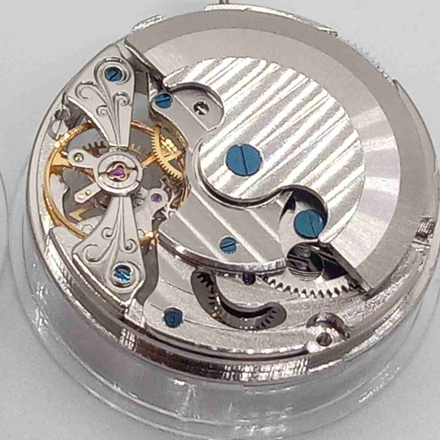 Silver hollow balance wheel with double mainspring, precise movement at 6 o'clock, ideal watch accessory.