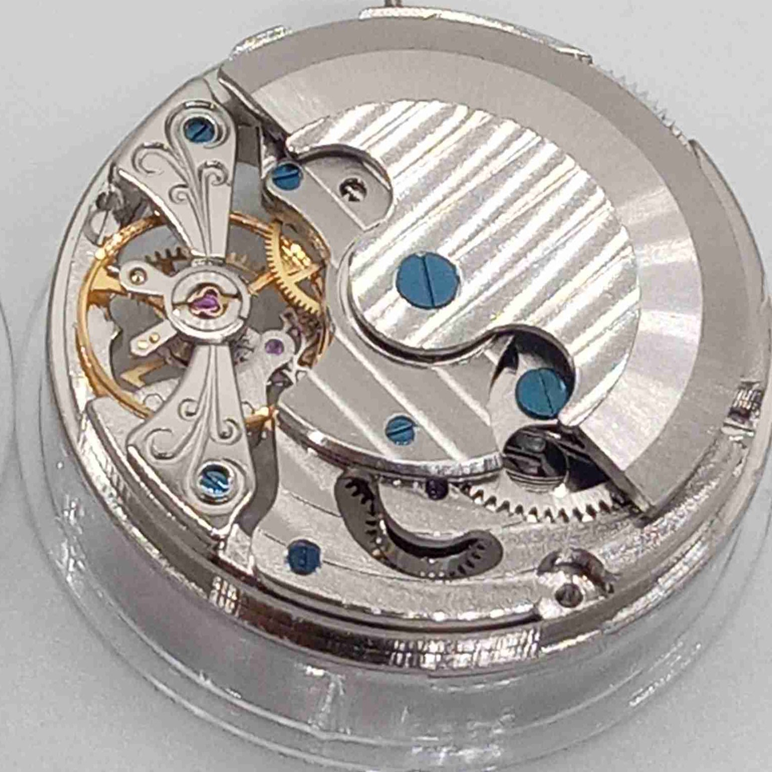 Silver hollow balance wheel with double mainspring, precise movement at 6 o'clock, ideal watch accessory.