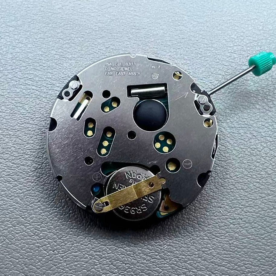 Swiss ISA 8371B quartz watch movement with date at 3 o'clock, white disk, silver-plated finish, precision timekeeping.