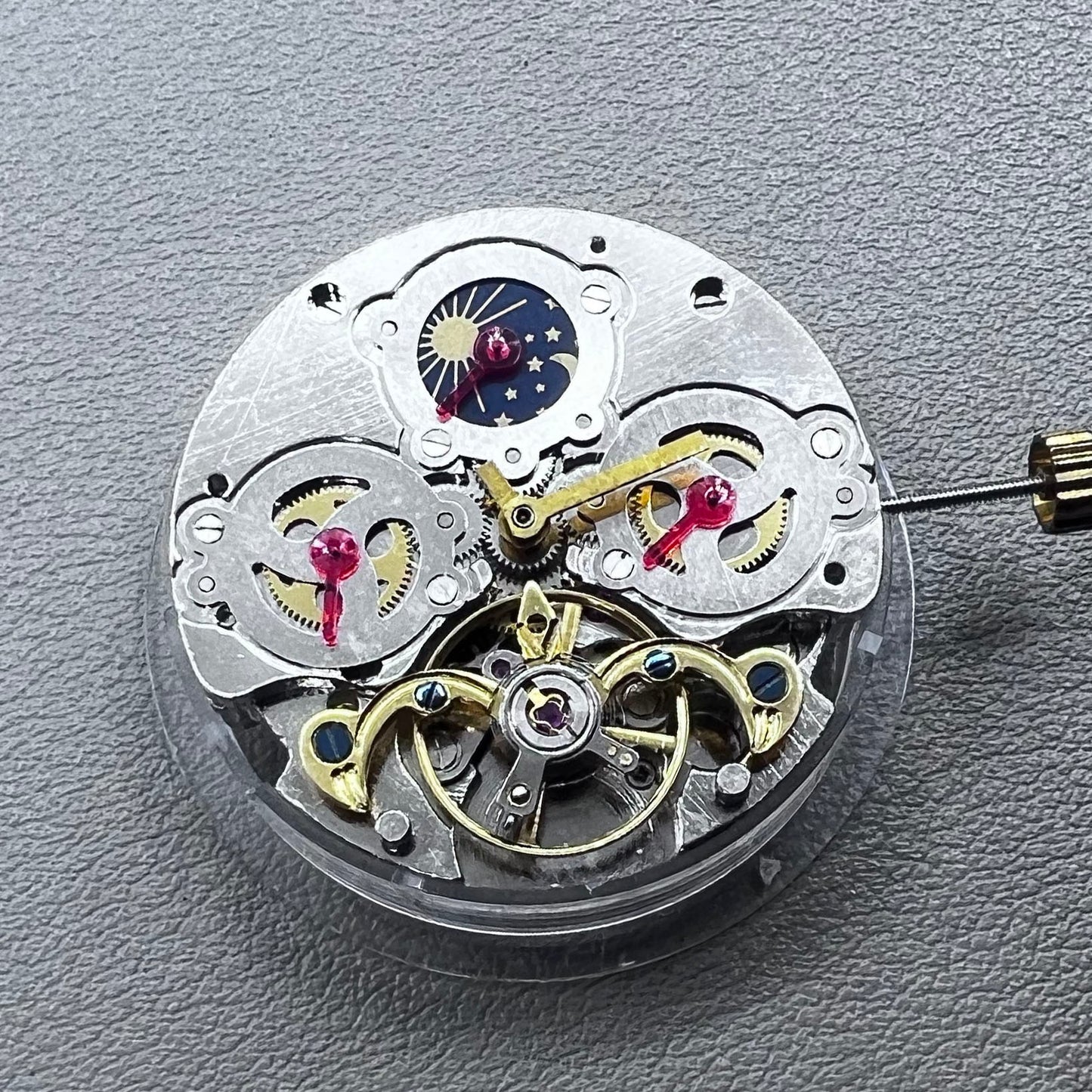China multifunctional automatic watch with mechanical movement, moon phase at 12 o?clock, and visible flywheel detail