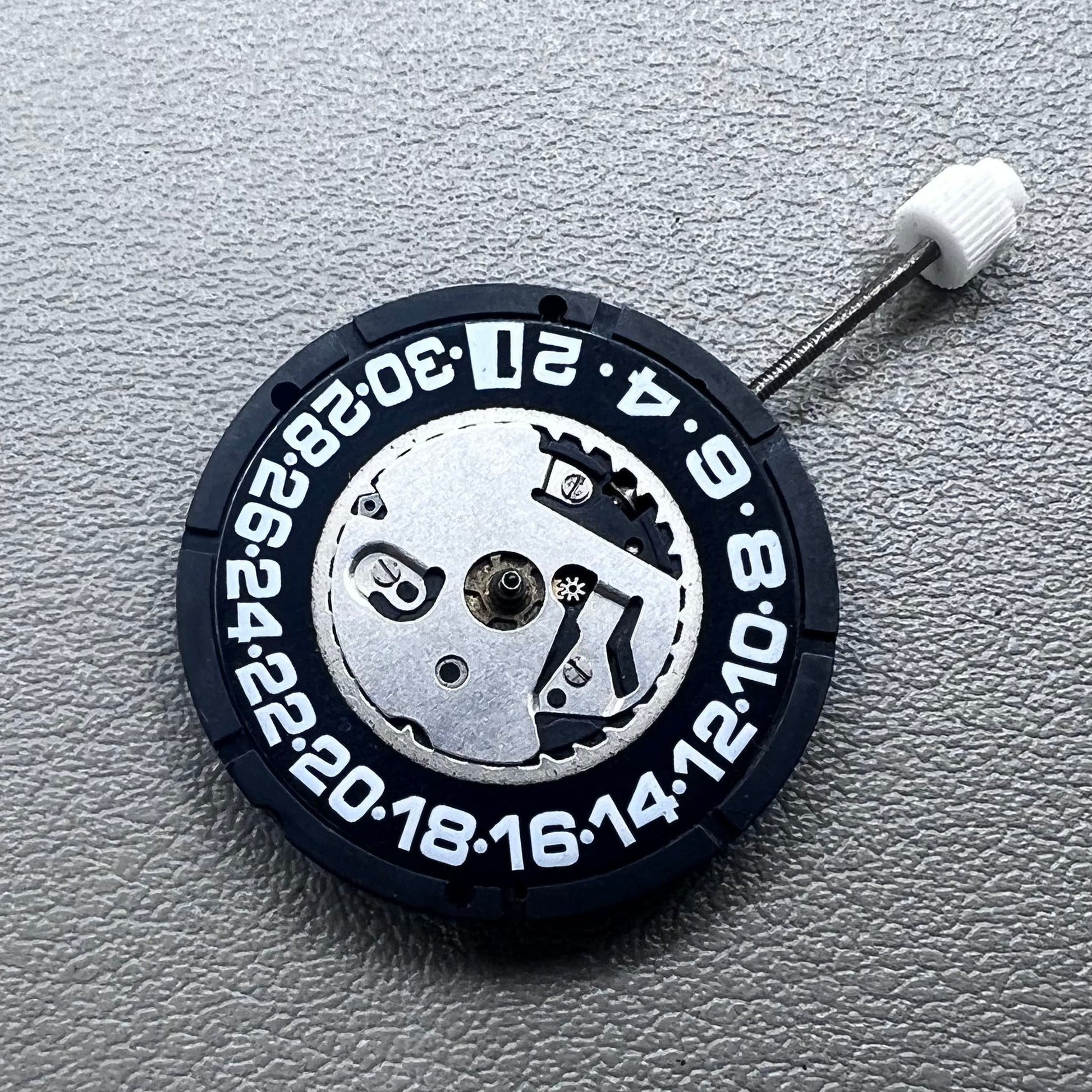 Swiss ISA 2330 quartz watch movement with black font date at 6 o'clock, precise 3-hand accessory.