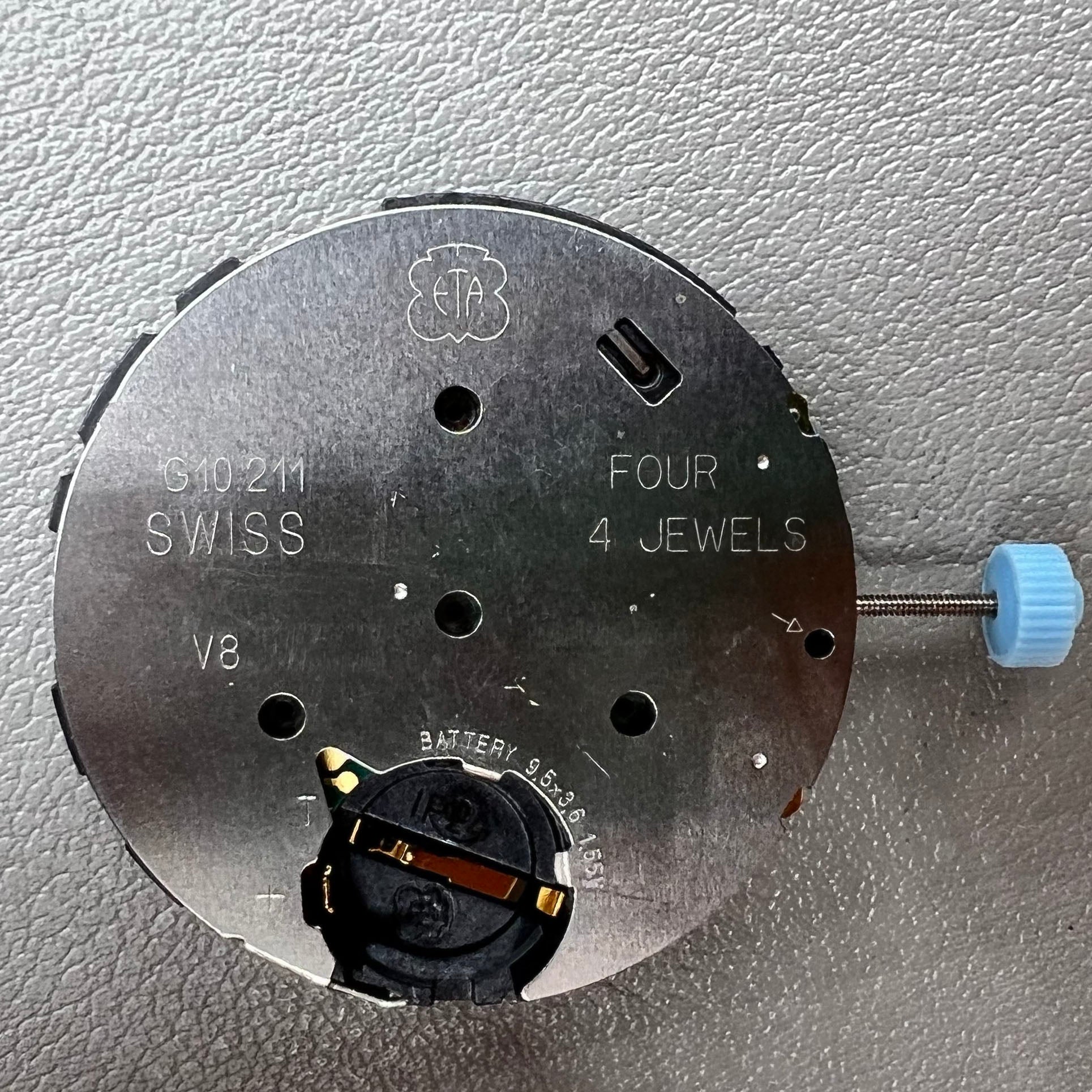 Swiss ETA G10.212 quartz watch movement with date at 4, large hands, small seconds, and black disk by ETA.