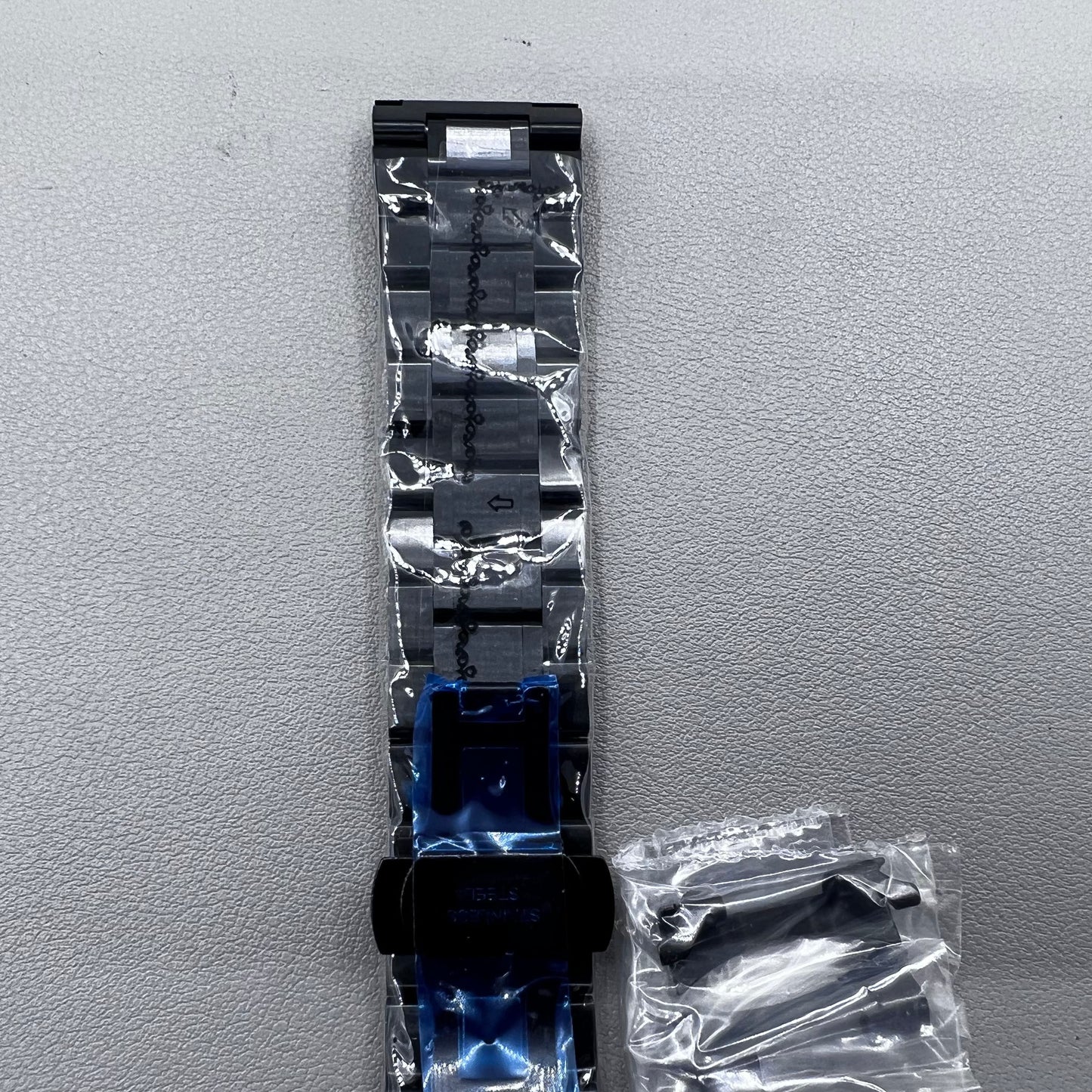 Curved end black steel 23mm watch band with butterfly clasp, durable and stylish.