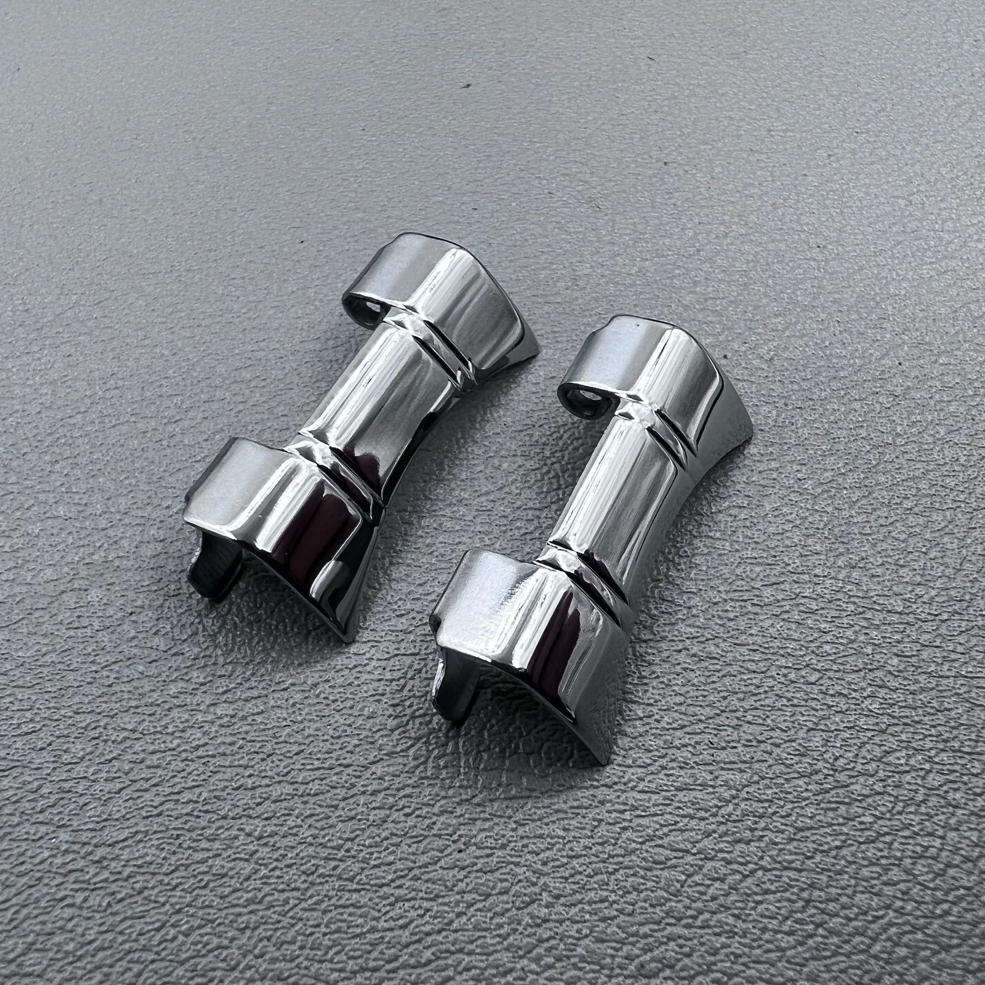 Set of 2 silver steel curved end links with spring bars for 24x12mm watch bands, enhancing bracelet fit.