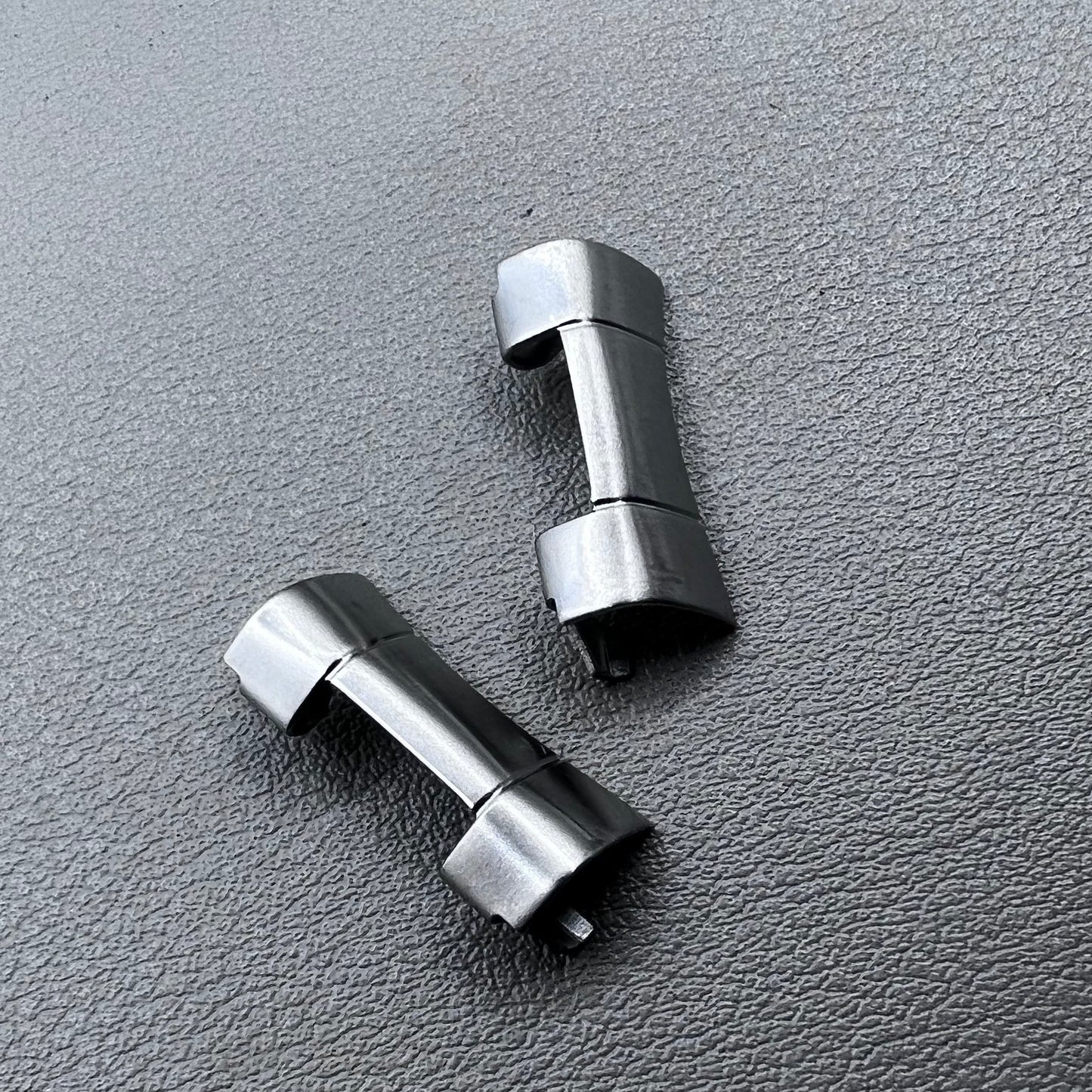 Set of 2 polished silver steel curved end links, 20x10mm, for secure watch band attachment.