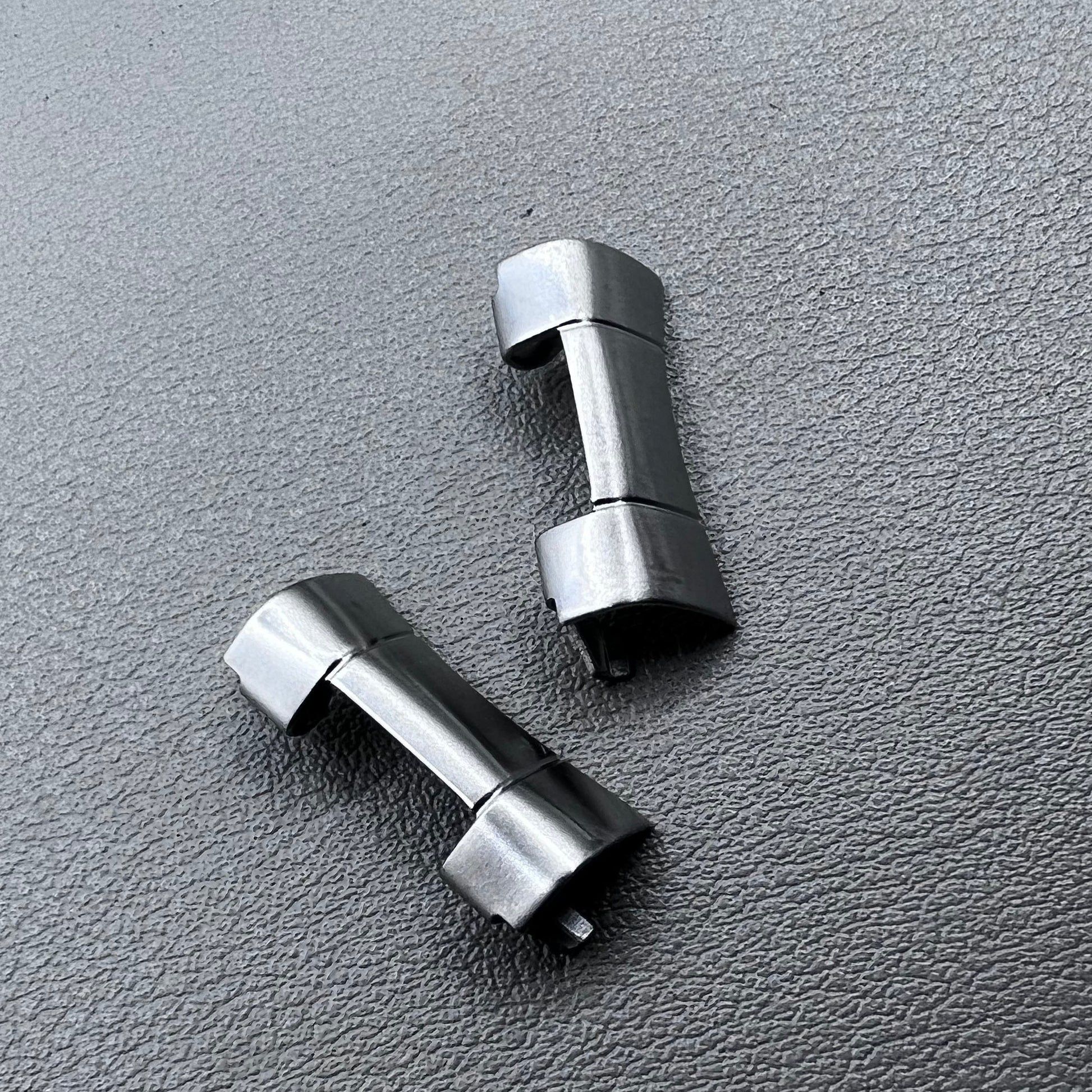 Set of 2 polished silver steel curved end links, 20x10mm, for secure watch band attachment.