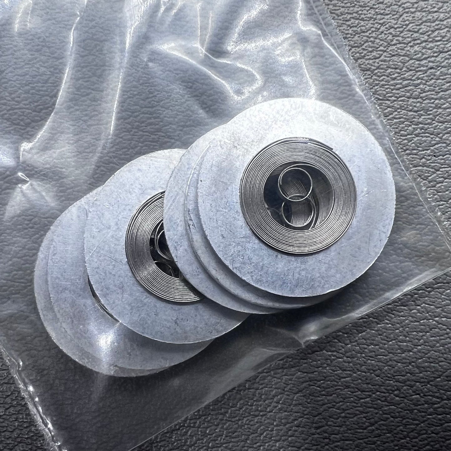 Silver mainspring set for movement 7009#180, generic fit, 5 pieces for precise watch repair.
