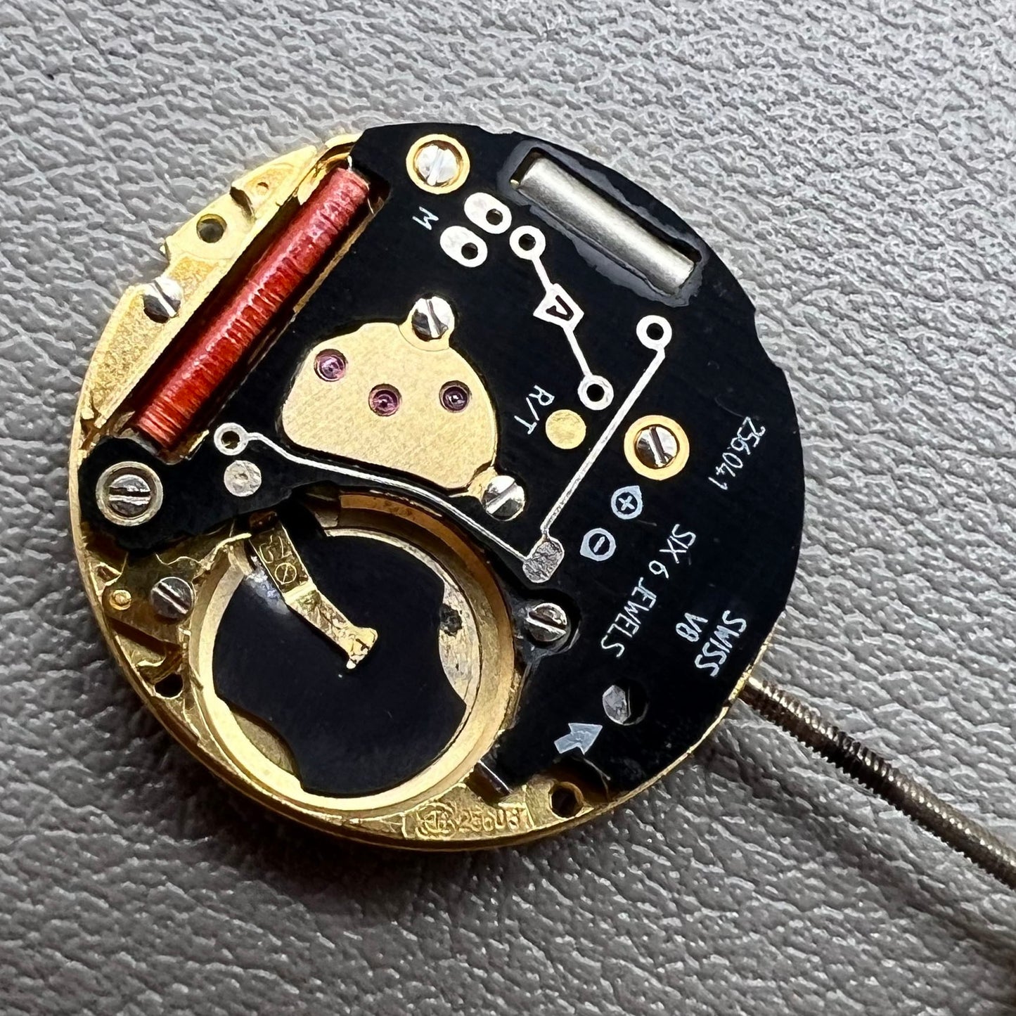 Swiss ETA 256.041 quartz watch movement with black disk, 2 hands, and date at 6, precise timekeeping.