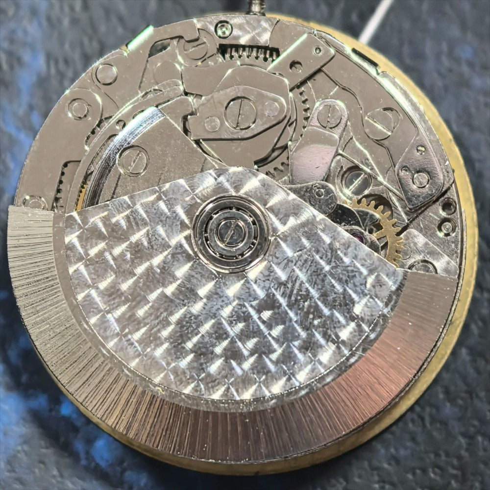 Dandong 7750 mechanical watch movement with black date disk at 3 o'clock, precision engineering.