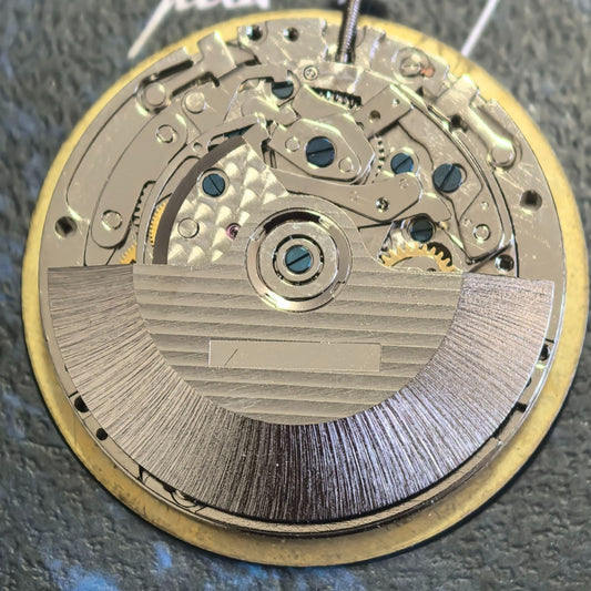 Chinese Dandong 7750 mechanical watch movement showing date at 3 and small seconds at 6, 9, 12 positions.