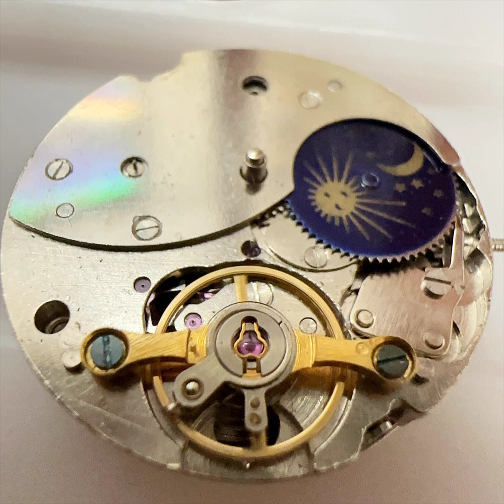 China Made 7120 mechanical watch movement showing moon phase, date at 3, balance wheel at 6.