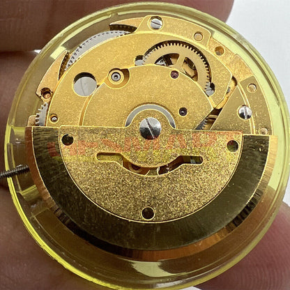 DG2813 automatic mechanical watch movement with golden finish, showing day and date functions.