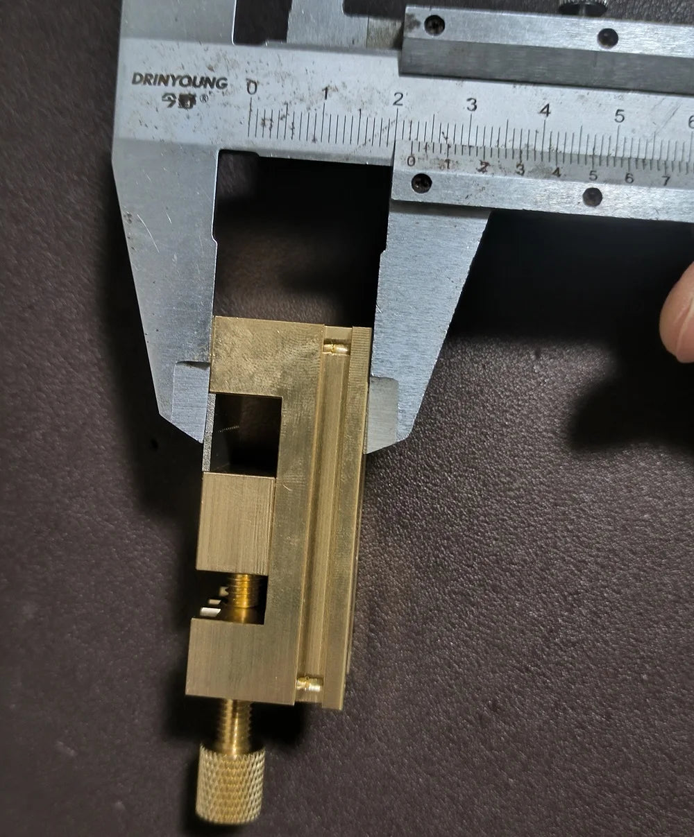 Copper Pointer Tube Clamp manual vise for watch repair on desktop, ideal for precise watch accessory adjustments.