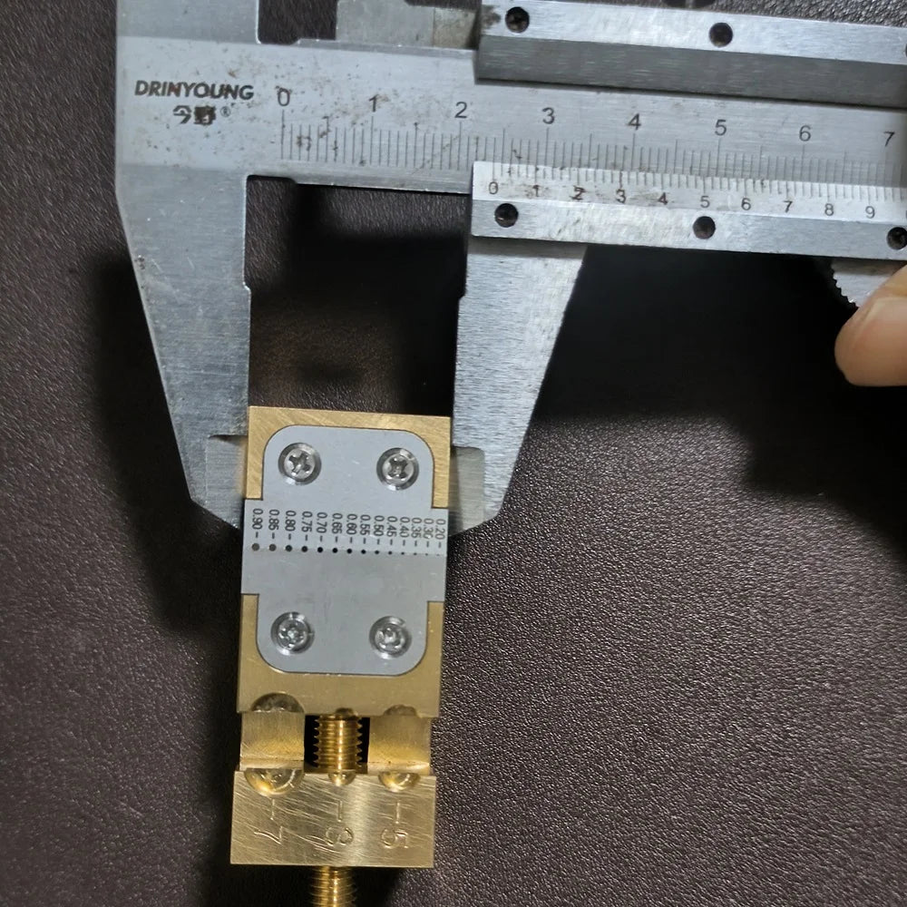 Copper Pointer Tube Clamp manual vise for watch repair on desktop, ideal for precise watch accessory adjustments.