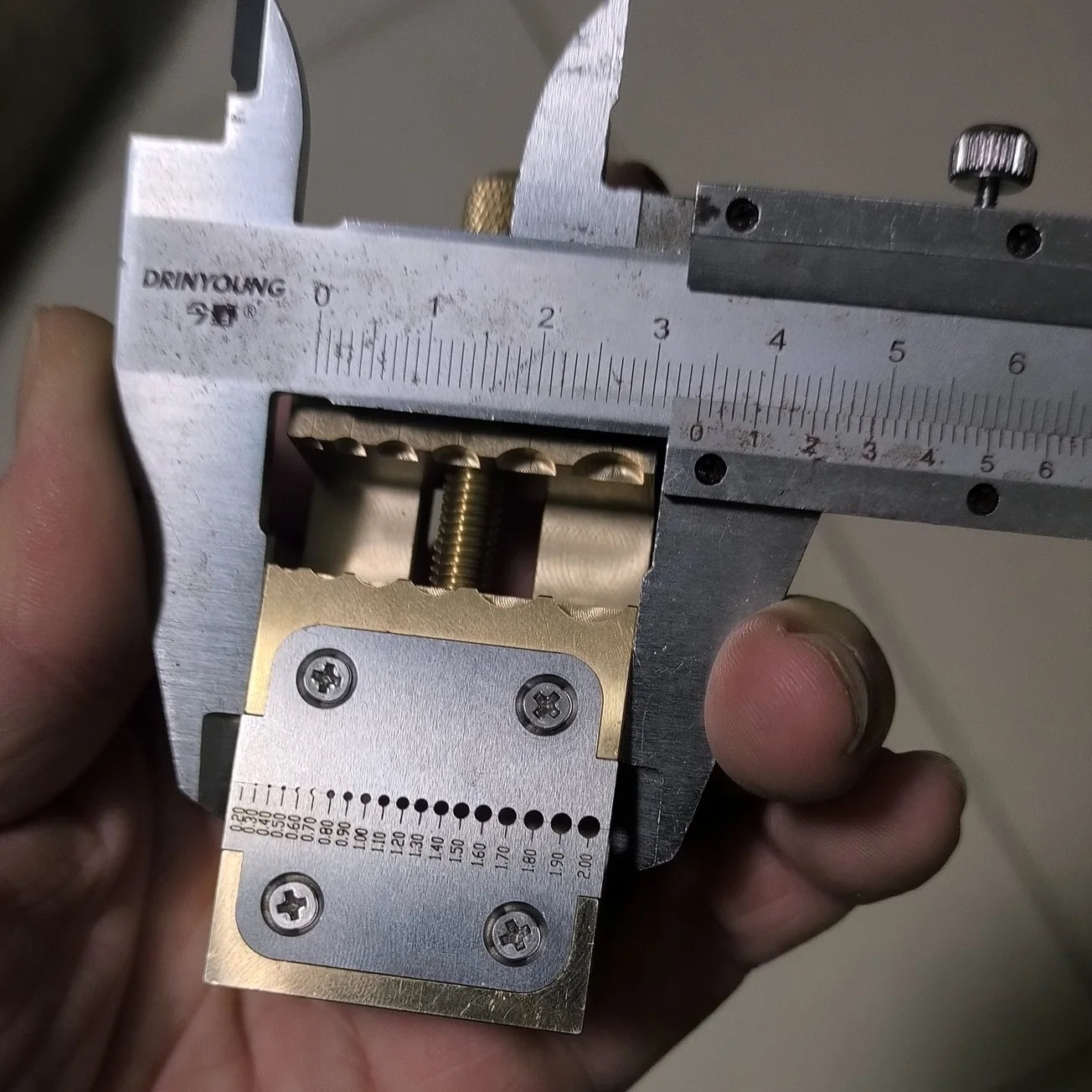 Copper watch repair tool with pointer tube clamp and manual vise for precise desktop watch fixing.