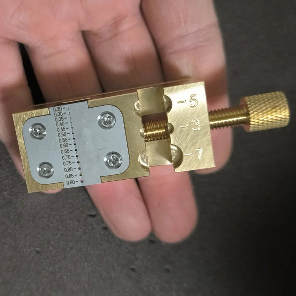 Copper Pointer Tube Clamp manual vise for watch repair on desktop, ideal for precise watch accessory adjustments.