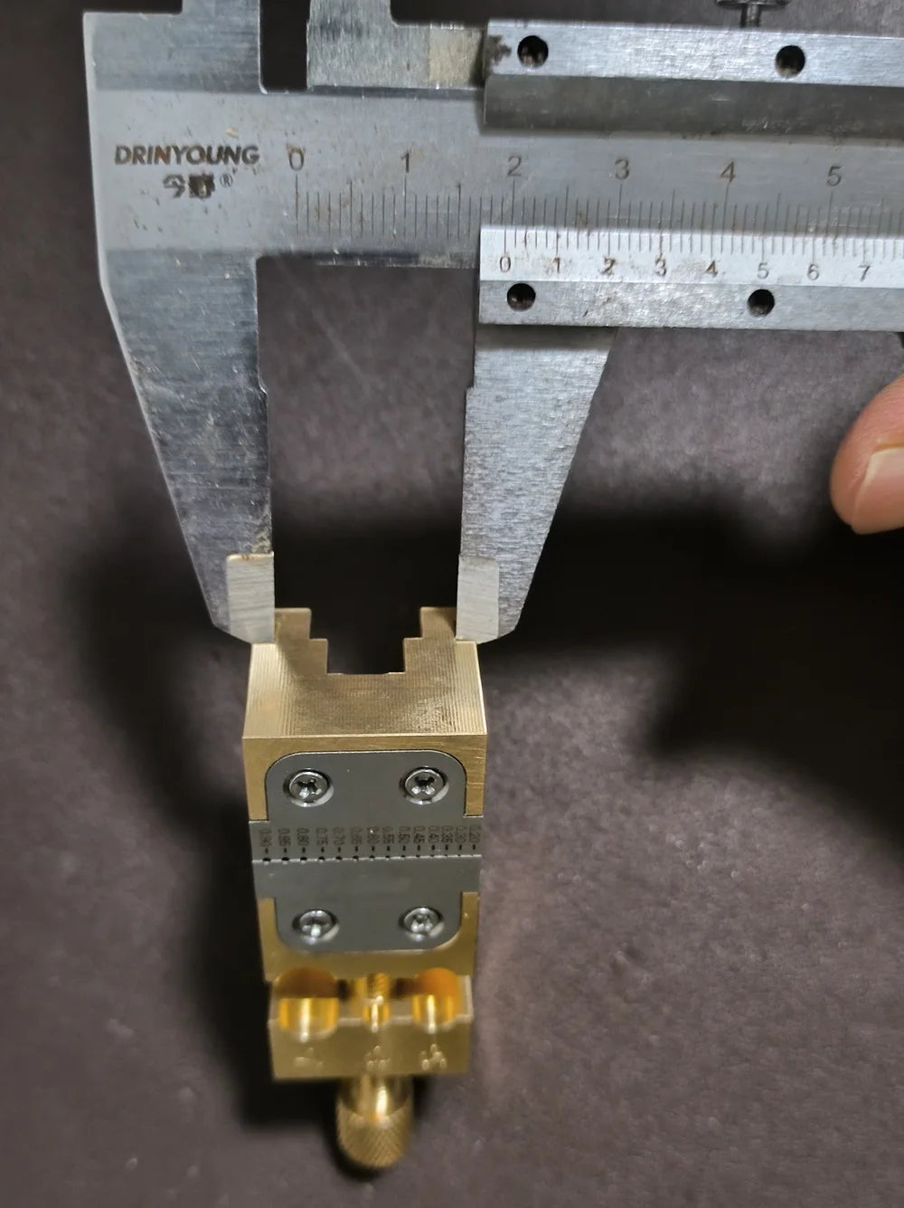 Copper Pointer Tube Clamp manual vise for watch repair on desktop, ideal for precise watch accessory adjustments.